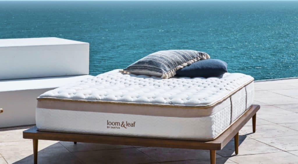 Loom & Leaf mattress on an outdoor flat bed frame beside the ocean.