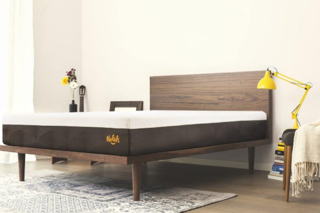 Nolah mattress on a simple wooden bed frame in a bedroom.